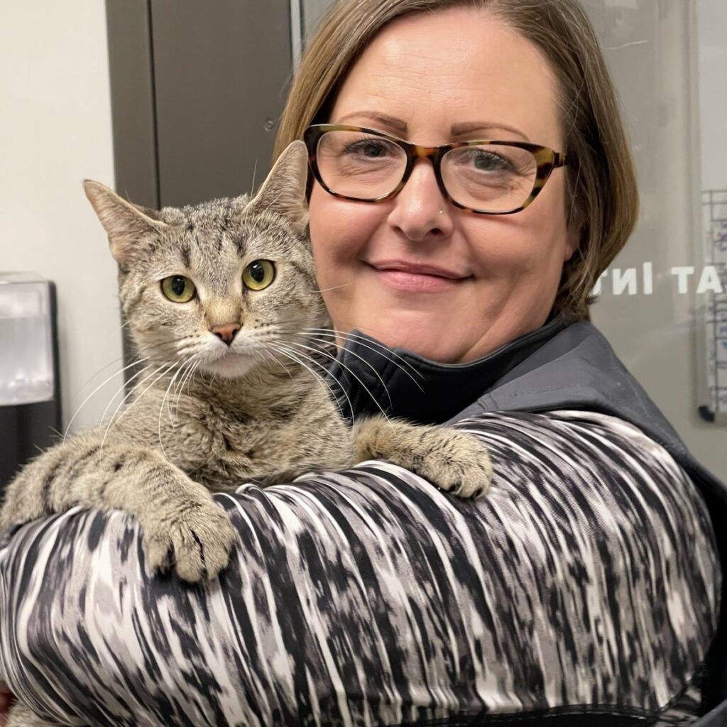 Jayne Fenton holding up a cat on her arm