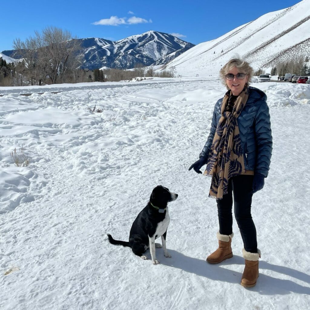 Sally Onetto and her dog standing in a beautiful snowy landscape